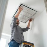 Homeowner replacing an HVAC air filter.