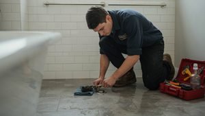 Standing water pooling around a shower drain during use.